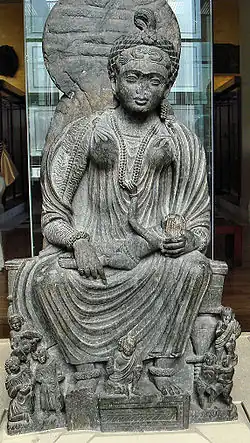 Statue of seated Hārītī with children from Yusufzai country around Peshawar, Pakistan in the British Museum, 2nd–3rd centuries CE[7]