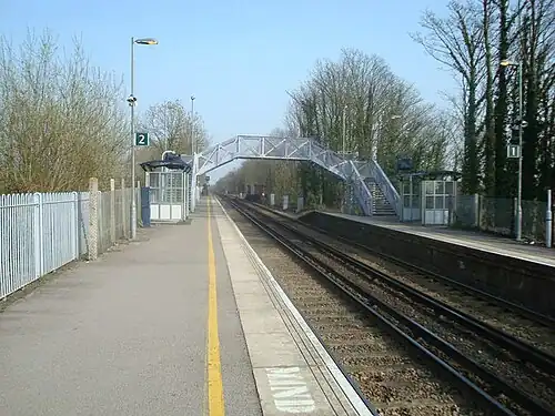 A railway station with two platforms, with a footbridge connecting them