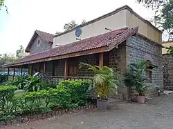 House made of stone and tiled sloping roof with garden in front