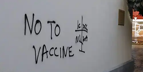 Anti-vaccine graffiti with orthodox cross at the Catholic Church in Ystad, 2021