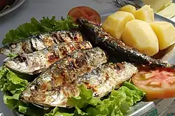 Portuguese grilled sardines on lettuce, with potato