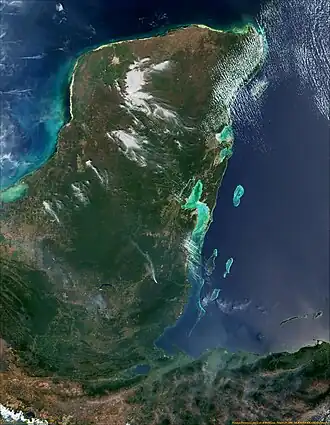 A satellite image of a large green landmass with blue water surrounding it on the left, top, and right.