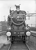 Steam locomotive NS 4310 (ex War Department no. 70863) at the central workshop in Tilburg, with decorations due to the fact that this was the last steam locomotive to be overhauled in the workshop in Tilburg. (07-06-1955)