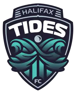 A club crest in the shape of a ship's bow, with waves forming the letter "x" crashing in front of it. The words "Halifax Tides" are written across the top of the ship, and "FC" is written below the waves.