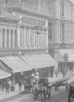 Another view of the 119–125 N. Spring store. Roofline sign: "SEE US FOR OVERCOATS"