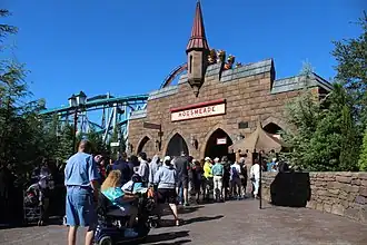A railway station with a brick façade and a turret in the middle