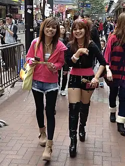 Young women in Hong Kong wearing layered street style with accessories and hairstyles influenced by Japanese gyaru and J-pop aesthetics, 2013.