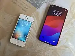 A (PRODUCT)RED iPhone 13 alongside a white iPhone 4s, in front side view