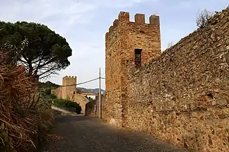 Walls and towers along a narrow, curved street