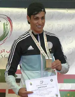 Imane Khelif wearing a gold medal at a sports competition.