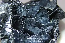 Shiny violet-black coloured crystalline shards.