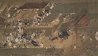 Very dense and lively crowd that occupies the entire space, crowding around several small buildings.