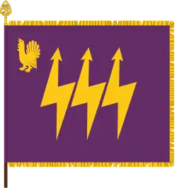 The traditional colour of the Eastern Finland Signals Battalion, part of the Karelia Brigade, has the branch colours of signals corps: purple and gold. The device featuring a western capercaillie is a throwback to the earlier designation as Central Finland Signals Battalion. The main device, the three lightning bolts, is symbolic of communication.
