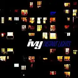 A portrait of an apartment building with several windows displaying light