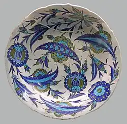 Iznik dish with an all-over design of composite lotus blossoms and rosettes overlapped in curved serrated leaves, c. 1545–1550. British Museum