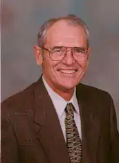 Joe Eddins. He is older man, wearing glasses, and looking straight at the camera