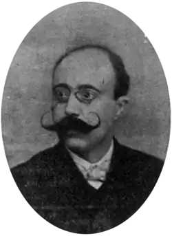 Portrait photograph of Josep Prat, wearing glasses and a curly moustache