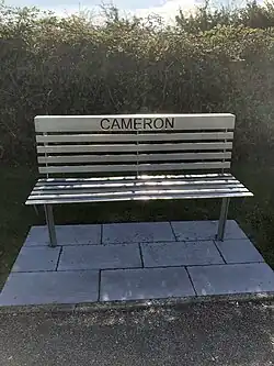 A metal bench with the name "Cameron" cut through the back.