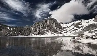 A body of water surrounded by snowy mountains in the background.