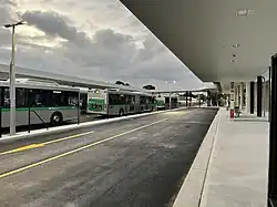 Bus interchange road with bus stops and a group of buses parked on the other side