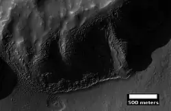 Layers in mantle deposit, as seen by HiRISE, under the HiWish program. Mantle was probably formed from snow and dust falling during a different climate. Location is Thaumasia quadrangle