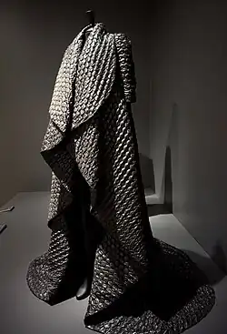 Black floor-length jacket in fabric made to look like bubble wrap