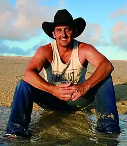 Man in black hat sitting on ground