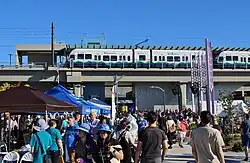 Western side of Lynnwood City Center Station on opening day with vendor booths and crowds in the foreground.