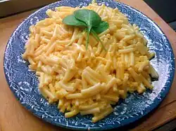 American Kraft Mac & Cheese served on a plate in Sweden, garnished with fresh spinach leaves