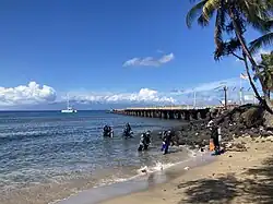 A view of the ocean, with a deteriorating steel pier on the right-hand side