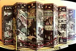 Coromandel lacquer screen with figures in pavilions and a main border with a "hundred antiques".