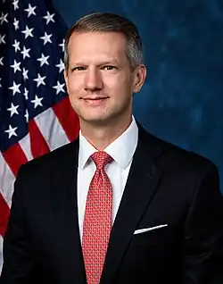 Official House portrait of Moore in front of the U.S. flag, wearing a black suit, white shirt, and red and white tie.