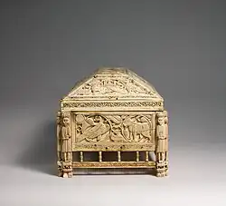 End view of the casket showing the detailed carvings and the guards on the corners.