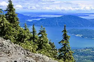 Summit of a mountain looking down onto lakes below, with trees on the summit