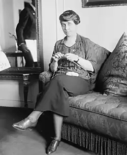 Coolidge looking at the camera while knitting