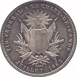 Crossed standards and rifles intertwined with wreath. Coat of arms of canton of Neuchâtel superimposed. Radiant Swiss cross above. Legend and date along edge.