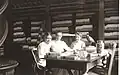 Photograph of three of Nevins Memorial Library's earliest librarians. Seated at the table in the Reference Room are: Miss Alice Chase, Miss Crosby and Miss Tooday Dorsey. Reference books are in the background and artifacts from the Nevins Historic Collection (Pheasant, Vase, Table and Richsonian Chair) are visible.[6]