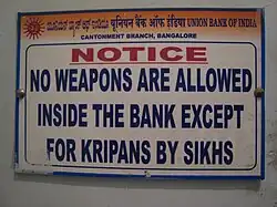 Sign reading "No weapons are allowed inside the bank except for kripans by Sikhs." "Kirpans" is misspelled as "kripans".