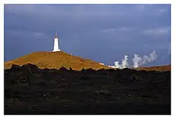 Reykjanesviti lighthouse with steam from the geothermal area of Gunnuhver
