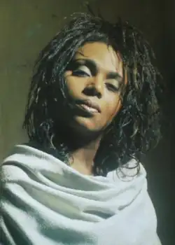 Brown wearing a white cloak, hair in dreadlocks