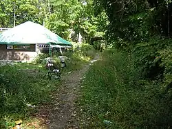 Before paving. Looking north past Bryn Mawr Park station replica, under Palmer Road, 2007