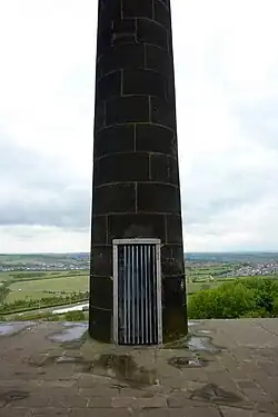 A door in a stone column, covered with a metal grate