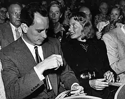 A black-and-white photo of Petter Lindström in a suit, beside actress Ingrid Bergman.