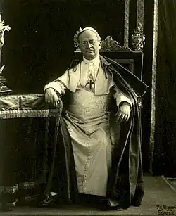 Pope Pius XI in ordinary dress: zucchetto, pectoral cross, cassock, and the papal tabarro, that similar to the ferraiolo.