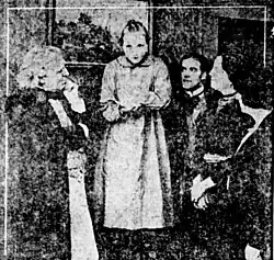 Black and white photograph showing several actors on a film set