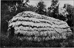 Home made of many horizontal layers of straw, creating a long and narrow structure