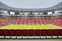 Photograph of a modern football stadium's interior; the stands are full of spectators