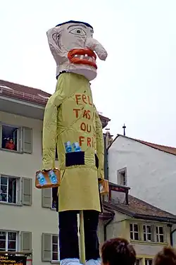 "Grand Rababou" (from the French word rababouêt, 'voleur de bois', poor wood thief) depicted here with the classic anti-Semitic stereotypes of hooked nose, bags and suitcases full of money is burnt annually in the ″Carnaval des Bolzes″ of Fribourg, Switzerland