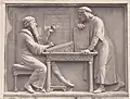 Detail of first bas-relief: Gutenberg showing types to Johann Fust