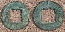 Two green coins with square holes